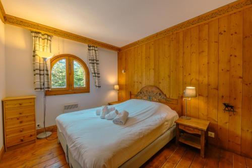 1 dormitorio con 1 cama y pared de madera en Résidence Le Cristal - Mont Blanc 6 - Happy Rentals, en Chamonix-Mont-Blanc