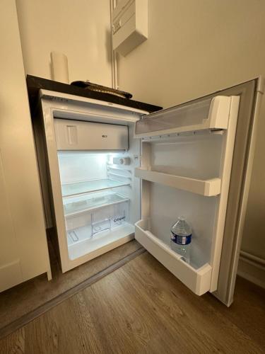 un réfrigérateur vide avec une porte ouverte dans une pièce dans l'établissement Au colombage de Chalon, centre ville quartier historique, à Chalon-sur-Saône
