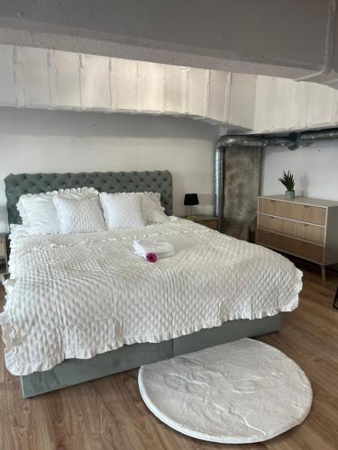 a bedroom with a large bed with a white comforter at Loveloft226 in Żyrardów