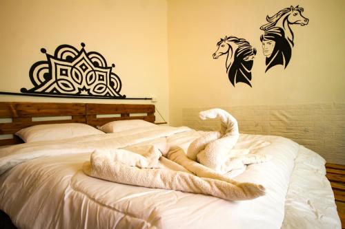 a bed with a white animal laying on it at Petra NefNaf Hostel in Wadi Musa