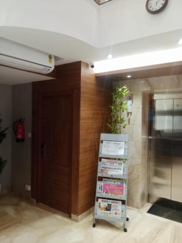 a book shelf in a room with a clock on the wall at Grand Courtyard Business Hotel in Chennai