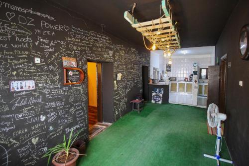 a room with a chalkboard wall with a green floor at Petra NefNaf Hostel in Wadi Musa