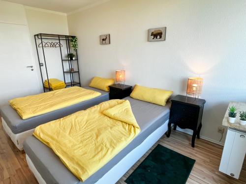 2 camas en una habitación con sábanas amarillas en LTA - Wohn- und Ferienapartment in Unterschleißheim bei München, en Unterschleißheim