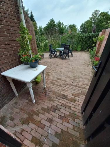 a patio with a white picnic table and chairs at Vakantiewoning - Veurom in Ommen