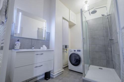 une salle de bain avec un lavabo et une machine à laver dans l'établissement Colorful - Cathédrale, à Reims