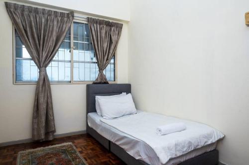 Cama en habitación con ventana en MyRehat Puncak Anthenauem 3 Bedroom, en Kuala Lumpur