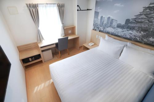 a bedroom with a white bed and a desk and a window at Travelodge Honmachi Osaka in Osaka