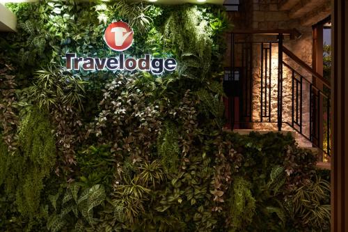 a wall covered in ivy with the travelodge sign on it at Travelodge Honmachi Osaka in Osaka