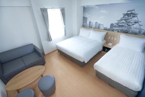a small room with two beds and a chair at Travelodge Honmachi Osaka in Osaka