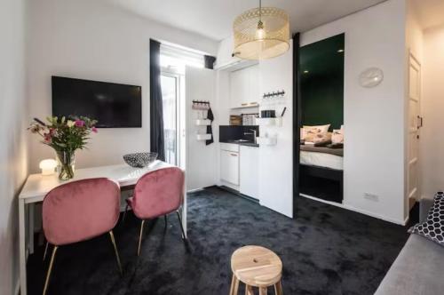a living room with a table and two pink chairs at Cozy 2-bedroom apartment in Amsterdam