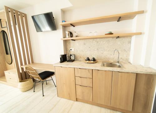 a kitchen with a sink and a chair in a room at Kali Thea Suites in Neos Marmaras
