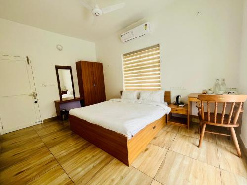 a bedroom with a bed and a desk and a chair at NIRVANA HAVEN HOME STAY in Trivandrum