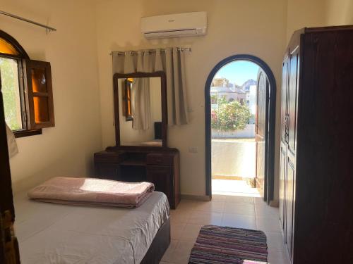 1 dormitorio con cama, espejo y puerta en Malaz Motel en Dahab