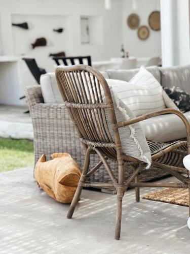 a wicker chair and a couch in a living room at Bliss on the Bay in Struisbaai