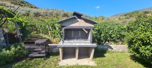 a bird house sitting in a yard with a grill at Agriturismo La Collina Verde in Levanto
