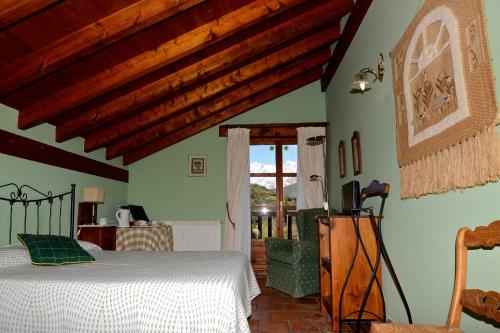 Hotel-Posada La Casa de Frama في Frama: غرفة نوم بسرير في غرفة بسقوف خشبية