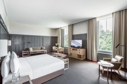 a hotel room with a bed and a television at COMO The Treasury in Perth