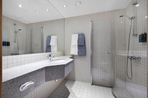 a bathroom with a shower and a sink at Clarion Hotel Tyholmen in Arendal