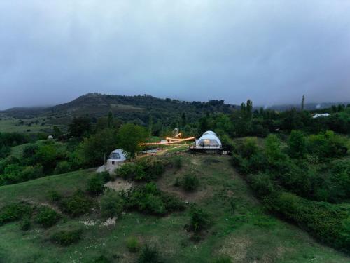 an aerial view of a house on a hill with a dome at Glamping Dream Domes Ismayilli in İsmayıllı