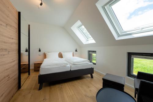a bedroom with a bed in a room with skylights at LUV - Haus am See in Streu