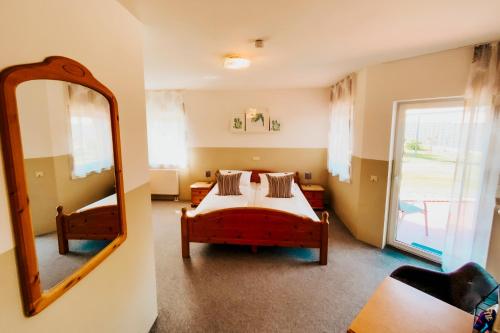 1 Schlafzimmer mit 2 Betten und einem Spiegel in der Unterkunft Gästehaus Windhagen in Windhagen