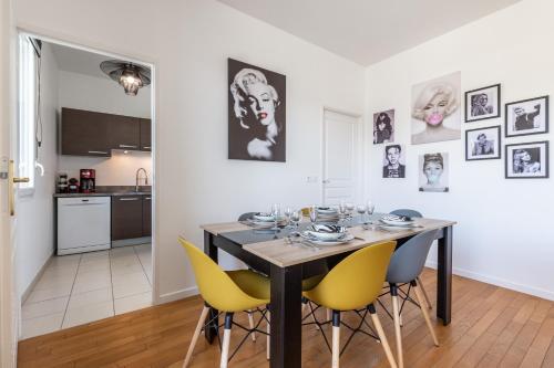 une salle à manger avec une table et des chaises jaunes dans l'établissement Luxe Penthouse for 6 - Fairytale Factory, à Bussy-Saint-Georges