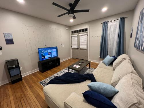 a living room with a couch and a flat screen tv at Midtown Hideaway: Just 3 miles from Everything! in Memphis