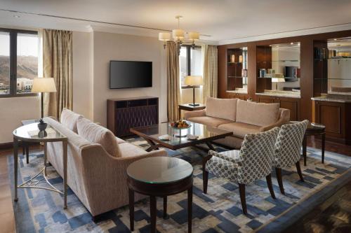 un soggiorno con divano, sedie e TV di Sheraton Oman Hotel a Mascate