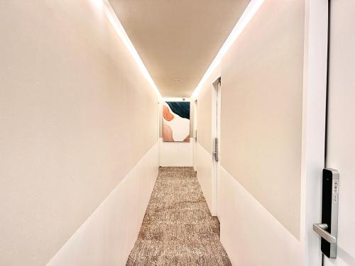 un pasillo de un pasillo con paredes blancas en 东京上野超级中心 设计师房间Ybob 上野公园3分钟 车站1分钟 超级繁华 免费wifi 戴森吹风, en Tokio