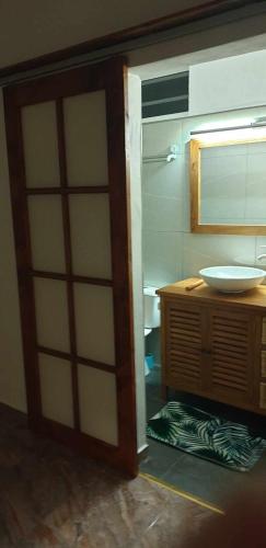 a bathroom with a door open to a sink at Ohana RBNB studio "Havai " in Uturoa
