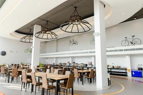 a dining room with tables and chairs and bikes on the ceilings at Tour De Phuket Hotel - SHA Plus in Thalang