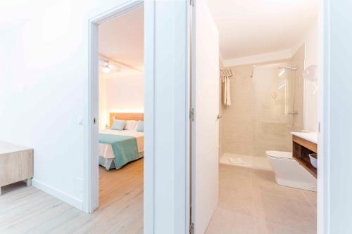 een witte kamer met een bed en een badkamer bij Ona Alborada in Costa Del Silencio