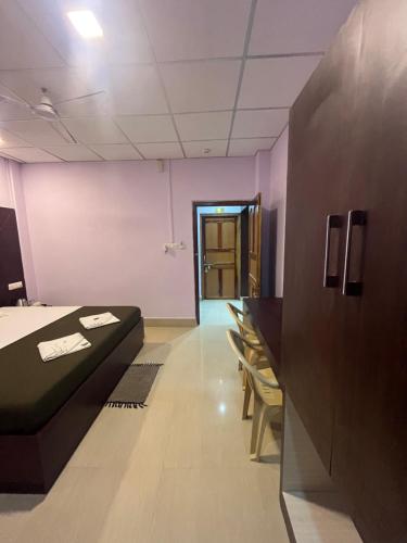 a room with a bed and a corridor with a door at Purnima Resort Neil Island in Neil Island