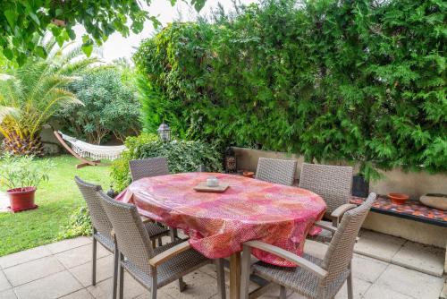 a patio table with chairs and a table cloth on it at P'tit Bout de paradis in Cavaillon