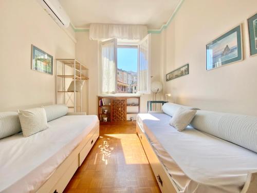 - un salon avec deux lits et une fenêtre dans l'établissement CasaViva - Comfy Trilo in Santa Margherita Ligure, à Santa Margherita Ligure