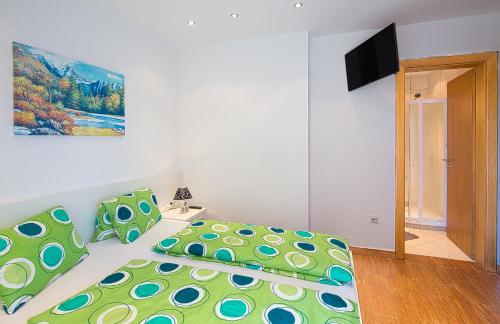 a bedroom with a bed with green and blue pillows at Montelux Apartments in Budva