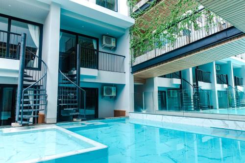 a swimming pool in front of a building at Tour De Phuket Hotel - SHA Plus in Thalang