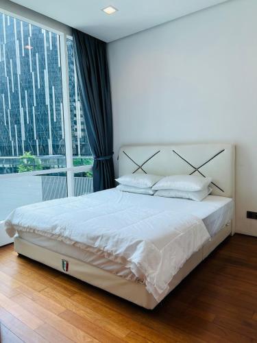 a bedroom with a large bed and a large window at SOHO Suites KLCC in Kuala Lumpur