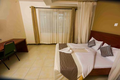 - une chambre avec un lit, un bureau et une fenêtre dans l'établissement Acacia Resort Wote-Makueni by Nest & Nomad, à Wote