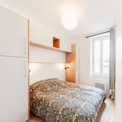 une chambre avec un lit et une fenêtre dans l'établissement Le Pavillon 50m de la Grande Plage, à Les Sables-dʼOlonne