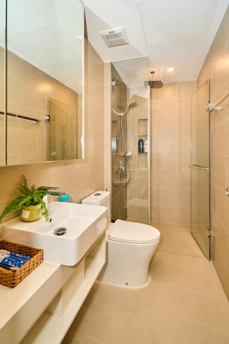 a bathroom with a toilet and a sink and a shower at The sóng Remy Apartment in Vung Tau