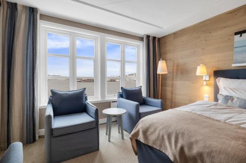 a hotel room with a bed and two chairs and a window at Clarion Hotel Tyholmen in Arendal