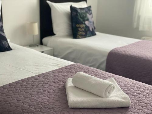 a white towel sitting on the corner of two beds at New modern APT near Old town - private parking in Zadar