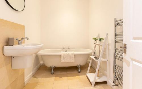 a bathroom with a sink and a tub and a toilet at 3-Bedroom Lower Ground Flat in Knaresborough Town Centre in Knaresborough