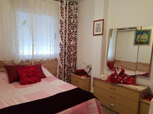 1 dormitorio con cama, tocador y espejo en Apartament Ania, en Torrevieja