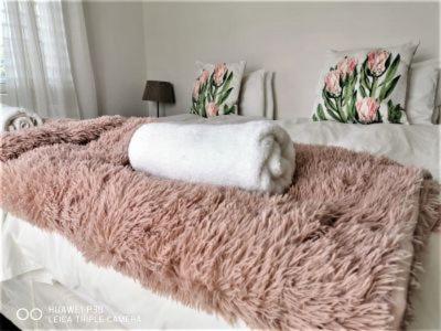 a white bed with a pink blanket on it at Mystic Breeze in Hermanus