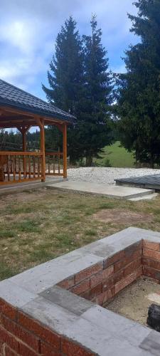 a park with a pavilion and a brick wall at Cabana Corbilor The Raven's Hut in Vatra Dornei