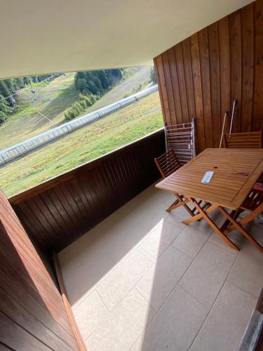 une pièce avec une table et des chaises et une grande fenêtre dans l'établissement Bartavelle Pied des pistes Praloup, à Uvernet