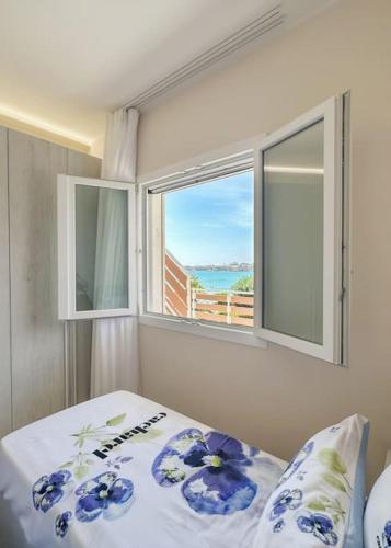 a bedroom with a bed with a view of the ocean at Taormina 10 PANTA REI Fontane Bianche in Fontane Bianche