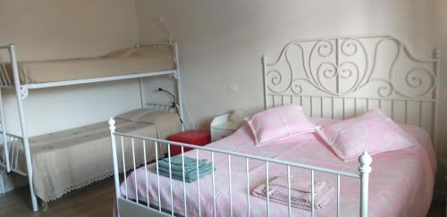 1 dormitorio con cama blanca y almohadas rosas en Casa Vacanze “Bouganville” loc Avane Pisa, en Vecchiano